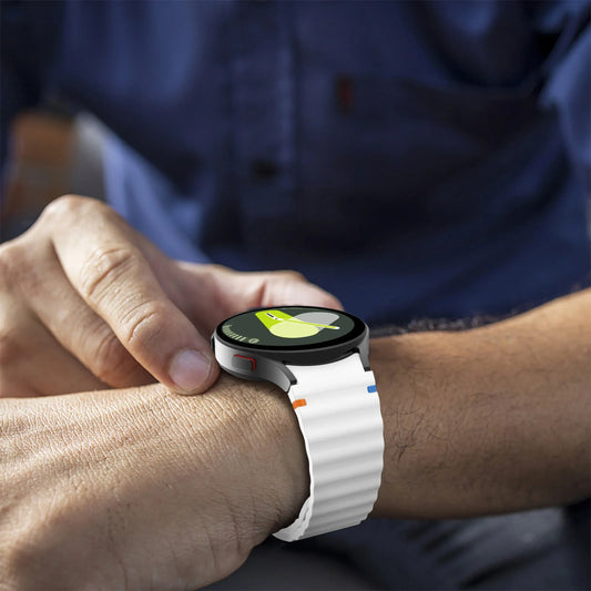 Person wearing a smartwatch with a white band on a blurred background